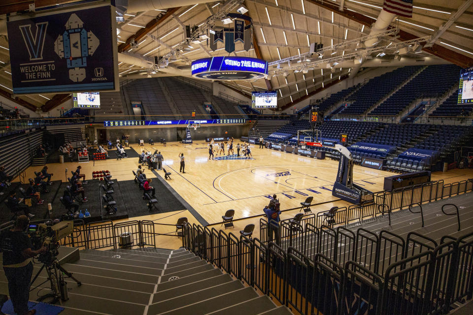 FILE - Villanova and Connecticut tip off at an NCAA college basketball game in an empty arena due to COVID-19 restrictions, Tuesday, Dec. 22, 2020, in Villanova, Pa. (AP Photo/Laurence Kesterson, File)