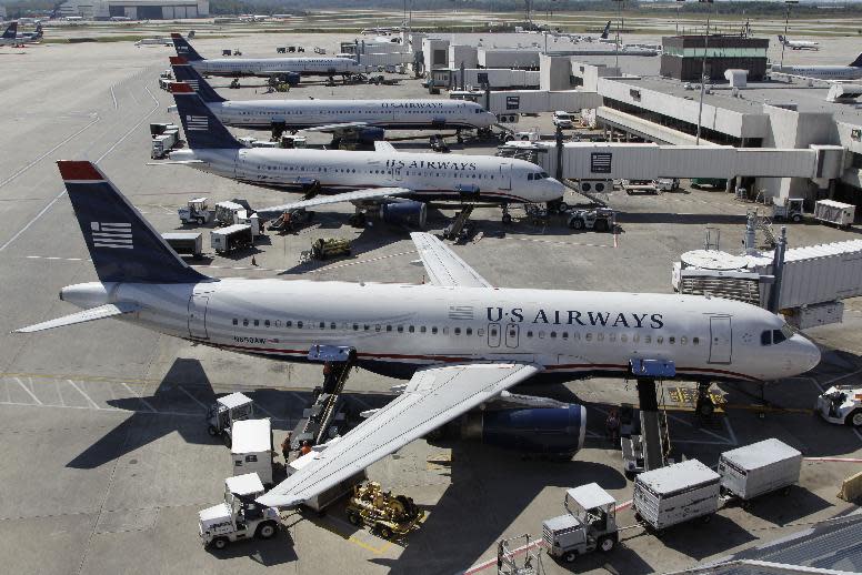 In this Thursday, Sept. 27, 2012, photo, US Airways jets are parked at their gates at the Charlotte/Douglas International airport in Charlotte, N.C. Patched together from several scrappy regional carriers on the brink of bankruptcy, US Airways has often been ridiculed within the aviation industry and remains a perennial afterthought among travelers. But it hopes to shed that image by merging with the larger American Airlines, in a deal which will catapult the two to the top of the industry. (AP Photo/Chuck Burton)