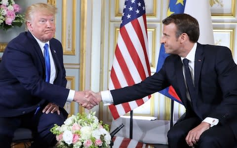 US President Donald Trump (L) and French President Emmanuel Macron shake hands during a meeting at the Prefecture of Caen, Normandy - Credit: &nbsp;Ludovic MARIN / POOL / AFP
