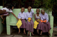 In this April 8, 2014 photo, boys with their clean-shaven heads sit and wait to be ordained during a ceremony at a Buddhist monastery in suburbs of Yangon, Myanmar. Though most boys only remain monks for a few days, the "shinbyu" or ordination ceremony, observed by Myanmar Buddhists, is said to date back more than two and half millennium, a religious gift given by Buddha to his own son, Rahula. (AP Photo/Gemunu Amarasinghe)