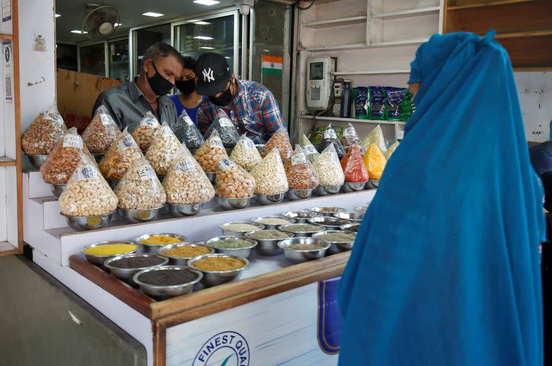 A Muslim woman buys dry fruit from a shop on the eve of the holy fasting month of Ramadan, in Ahmedabad