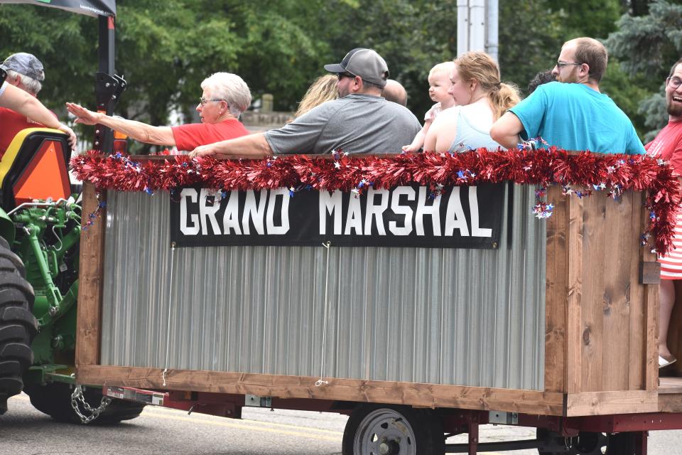 Marty Chrisman, seated in the red shirt at left, rides with family members and others through downtown Adrian Sunday, July 24, during the 2022 Lenawee County Fair parade. Chrisman, with more than 30 years of involvement with the fair, was named this year's parade grand marshal.