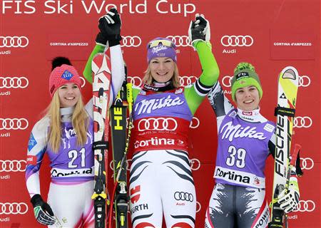 Maria Hoefl-Riesch of Germany (C) celebrates on the podium with second place Tina Weirather of Liechtenstein (L) and third place Nicole Schmidhofer of Austria, after winning the women's FIS World Cup Downhill race in Cortina D'Ampezzo January 24, 2014. REUTERS/Alessandro Garofalo