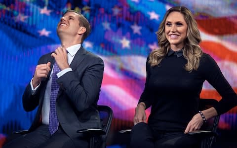 Eric Trump, left, fixes his tie as Lara Trump, right, smiles while they tape a segment of "Justice With Judge Jeanine," at the Fox Studios in New York, Friday, October 13, 2017 - Credit: AP
