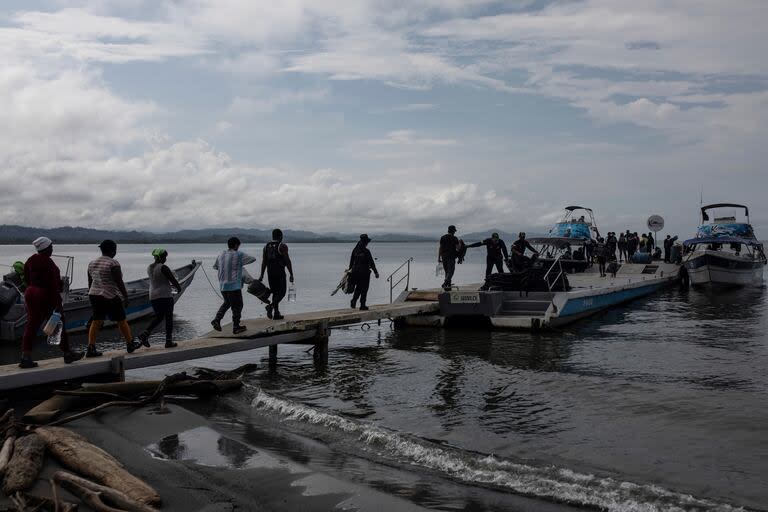 ARCHIVO - Migrantes abordan embarcaciones en la jungla del Tapón del Darién, en Necoclí, Colombia, (AP Foto/Iván Valencia, Archivo)