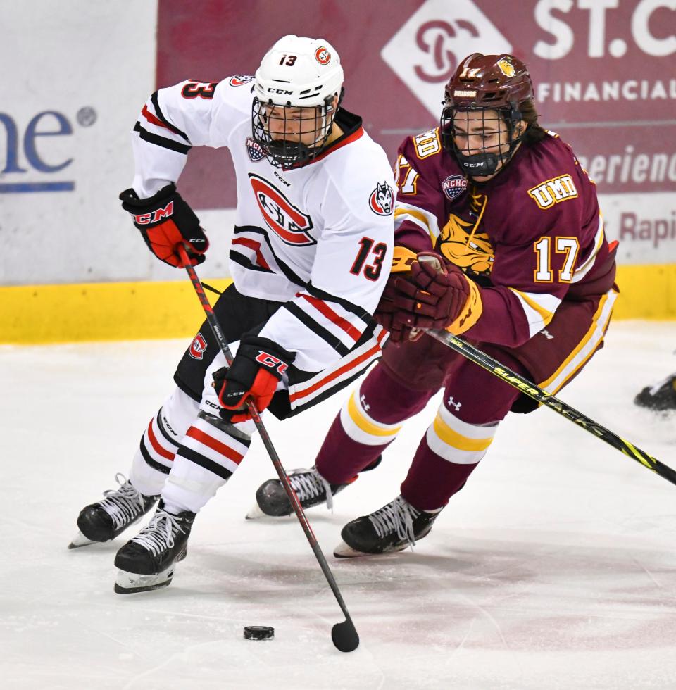 St. Cloud State's Jami Krannila and Dominic James of Minnesota-Duluth battle for the puck during the first period of the game Tuesday, Feb. 8, 2022, at the Herb Brooks National Hockey Center in St. Cloud. 