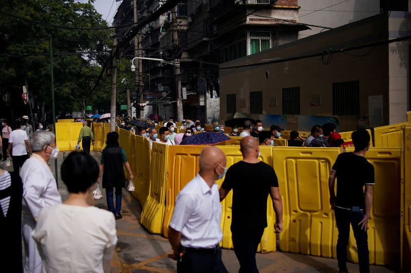 Residents wearing face masks line up for nucleic acid testings at a residential compound in Wuhan