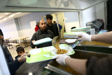 A migrant receives food in a migrant camp in Bihac, Bosnia and Herzegovina, December 14, 2018. REUTERS/Antonio Bronic