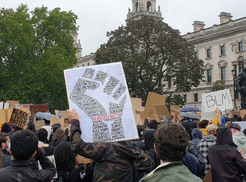 Demonstrators hold signs during a Black Lives Matter protest in Parliament Square, following the death of George Floyd who died in police custody in Minneapolis, in London