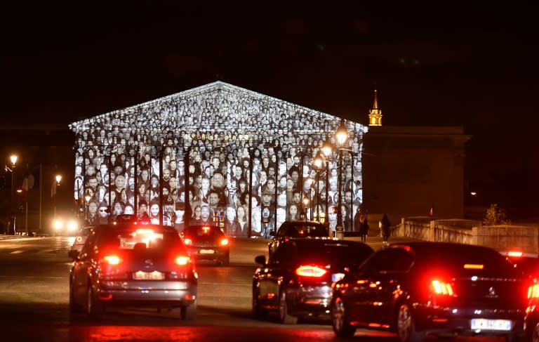 The images of more than 500 people are projected on the facade of the French National Assembly building during the 2015 UN Climate Change Conference (COP21) in Paris The Standing March is the collaborative work by the French artist known as JR and US filmmaker Darren Aronofsky