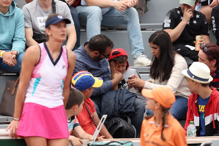 Los padres consuelan a su hijo después de que la rumana Irina-Camelia Begu lo golpeó en la cara sin intención tras hacer picar su raqueta, durante la segunda ronda del Abierto de Francia.