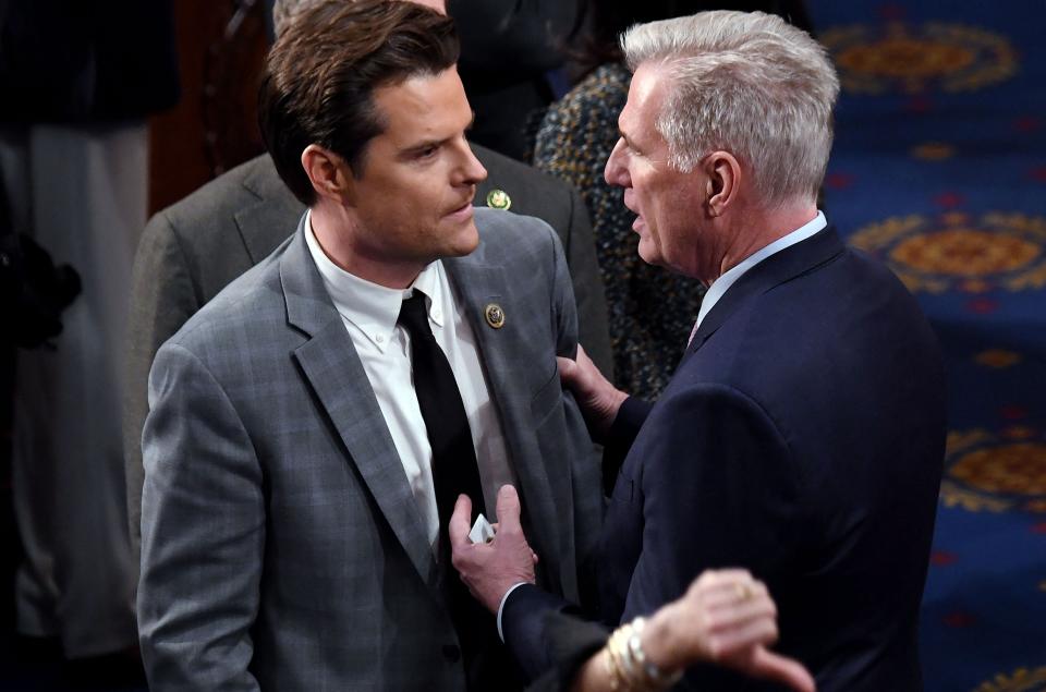 Kevin McCarthy holds Rep. Matt Gaetz by the arm in the House Chamber on Friday night. Gaetz looks cautiously triumphant. 