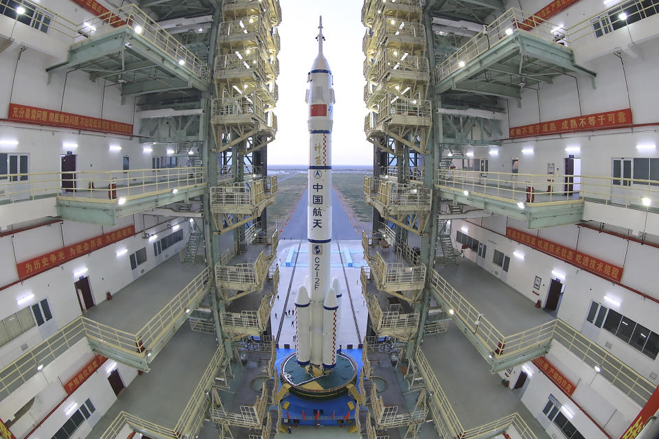 FILE - In this photo released by Xinhua News Agency, the Shenzhou-13 manned spaceship onto of a Long March-2F carrier rocket prepares to be transferred to the launching area of Jiuquan Satellite Launch Center in northwestern China, Oct. 7, 2021. China is preparing to send three astronauts to live on its space station for six months — a new milestone for a program that has advanced rapidly in recent years. It’s not just rocket fuel propelling America’s first moonshot after a half-century lull. Rivalry with China’s space program is helping drive NASA’s effort to get back into space in a big way. That's as both nations push to put people back on the moon and establish the first lunar bases. (Wang Jiangbo/Xinhua via AP, File)