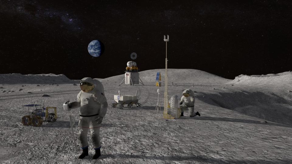 Two astronauts work on the surface of the moon.  They are surrounded by equipment and the Earth is visible in the background.