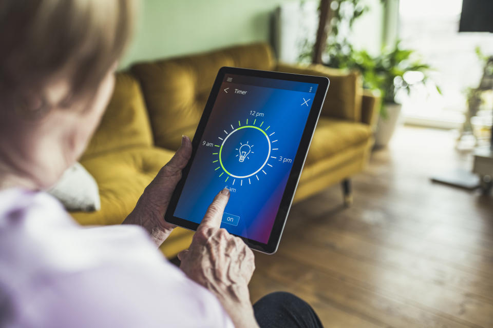 A woman sets a timer for her lights on her tablet