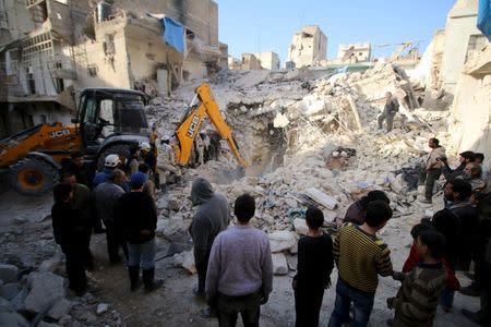 Civil defence members search for survivors after airstrikes by pro-Syrian government forces in the rebel held al-Qaterji neighbourhood of Aleppo, Syria February 14, 2016. REUTERS/Abdalrhman Ismail