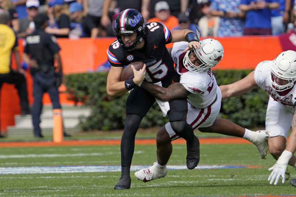 Arkansas linebacker Chris Paul Jr., center, sacks Florida quarterback Graham Mertz (15) during the first half of an NCAA college football game, Saturday, Nov. 4, 2023, in Gainesville, Fla. (AP Photo/John Raoux)