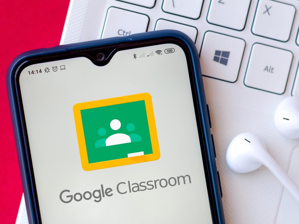 Google Classroom app on an Android phone resting on a Mac laptop