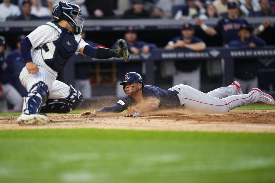 Boston Red Sox's Rafael Devers slides past New York Yankees catcher Jose Trevino to score during the fourth inning of a baseball game Friday, June 9, 2023, in New York. (AP Photo/Frank Franklin II)