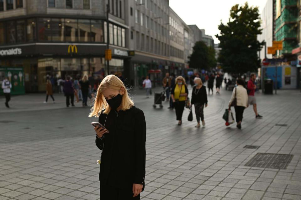 A woman wearing a protective face covering walks through Liverpool city centre, after the government imposed fresh restrictions on the city: AFP via Getty Images