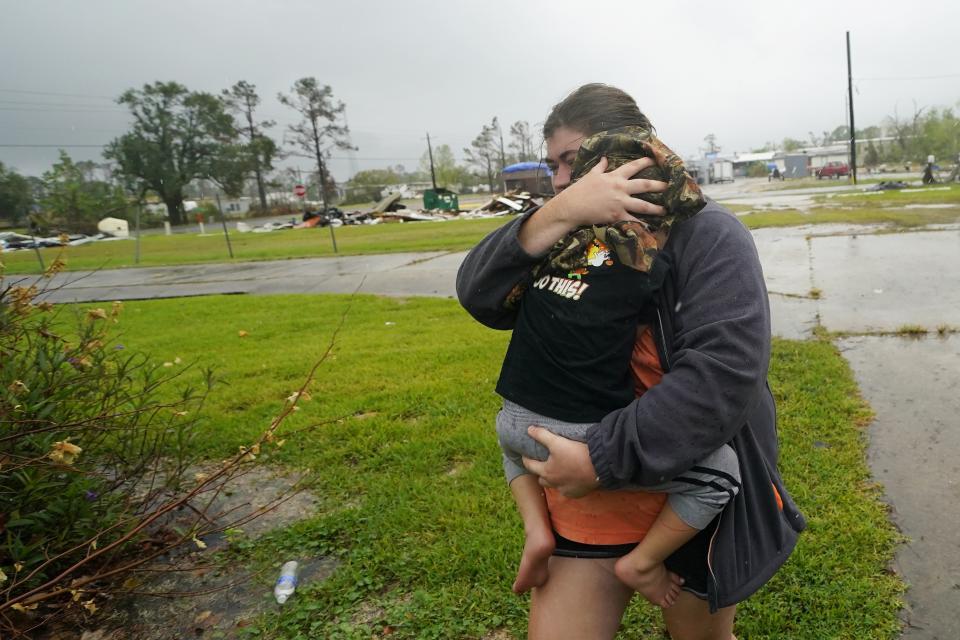 FILE - Danielle Fontenot runs to a relative's home in the rain with her son Hunter ahead of Hurricane Delta in Lake Charles, La., Oct. 9, 2020. A new study says that back-to-back hurricanes that hit the same general place in the United States seem to be happening more often. (AP Photo/Gerald Herbert, File)