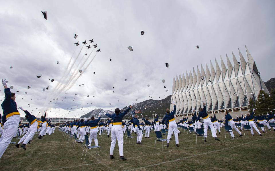 Members of the Air Force Academy's Class of 2020 celebrate as the Thunderbirds fly over their graduation ceremony.