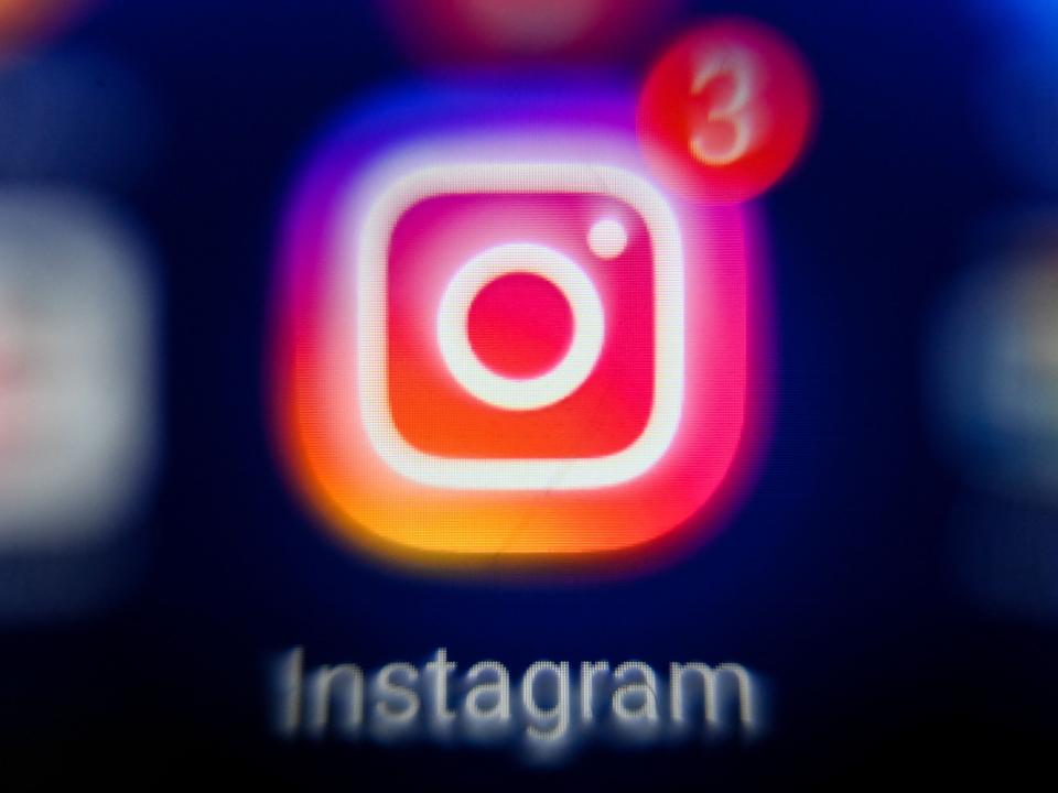 Instagram logo is blurred on an iPhone screen.