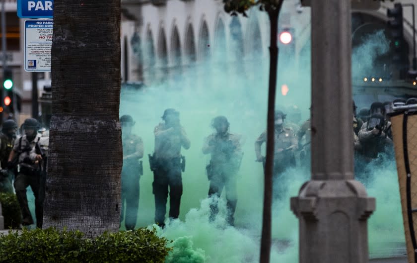 RIVERSIDE, CA - JUNE 1, 2020: Riverside County Sheriffs fire tear gas towards protesters after they moved a fence into the street during the coronavirus pandemic on June 1, 2020 in Riverside, California. Thousands of protesters marched through the street of downtown Riverside and police alloyed them to stay 90 minutes after the 6pm curfew.(Gina Ferazzi / Los Angeles Times)