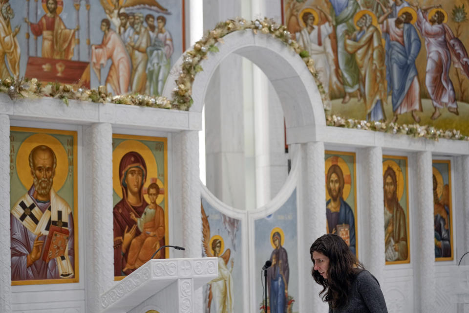 Before the start of a service, a woman examines some of the details at St. Nicholas Greek Orthodox Church in New York, Tuesday, Dec. 6, 2022. After a rebuilding process that lasted more than two decades, the Greek Orthodox church that was destroyed in the Sept. 11 attacks has reopened at the World Trade Center site. The St. Nicholas Greek Orthodox Church and National Shrine, designed by architect Santiago Calatrava, now overlooks the Trade Center memorial pools from an elevated park. (AP Photo/Seth Wenig)