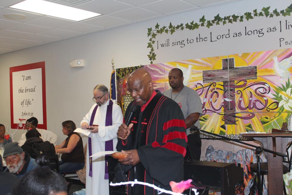 Bishop John Goldbolt of  One Church Covenant Fellowship recites scripture during morning breakkast at Operation Inasmuch. Eight pastors from seven Christian denominations held an Ash Wednesday service on Feb. 22, 2023, at Operation Inasmuch, a downtown nonprofit in Fayetteville, NC, that serves the homeless and people in need.