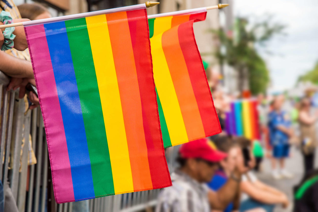 Gay rainbow flags at Montreal gay pride parade with blurred spectators in the background