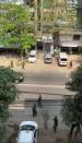 A soldier points their gun at a balcony on a street in Yangon