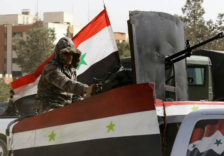 A member of Syrian regime forces sits in an armed vehicle at the entrance of Harasta in Eastern Ghouta, near Damascus, on March 22, 2018, after a deal was struck with rebels to evacuate the town