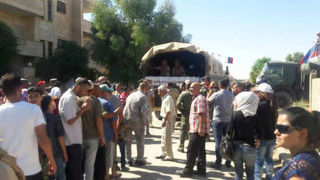 Syrian people are seen as they receive aid from Russian forces in Deir al Zor, Syria in this handout picture provided by SANA on September 10, 2017, Syria. SANA/Handout via REUTERS