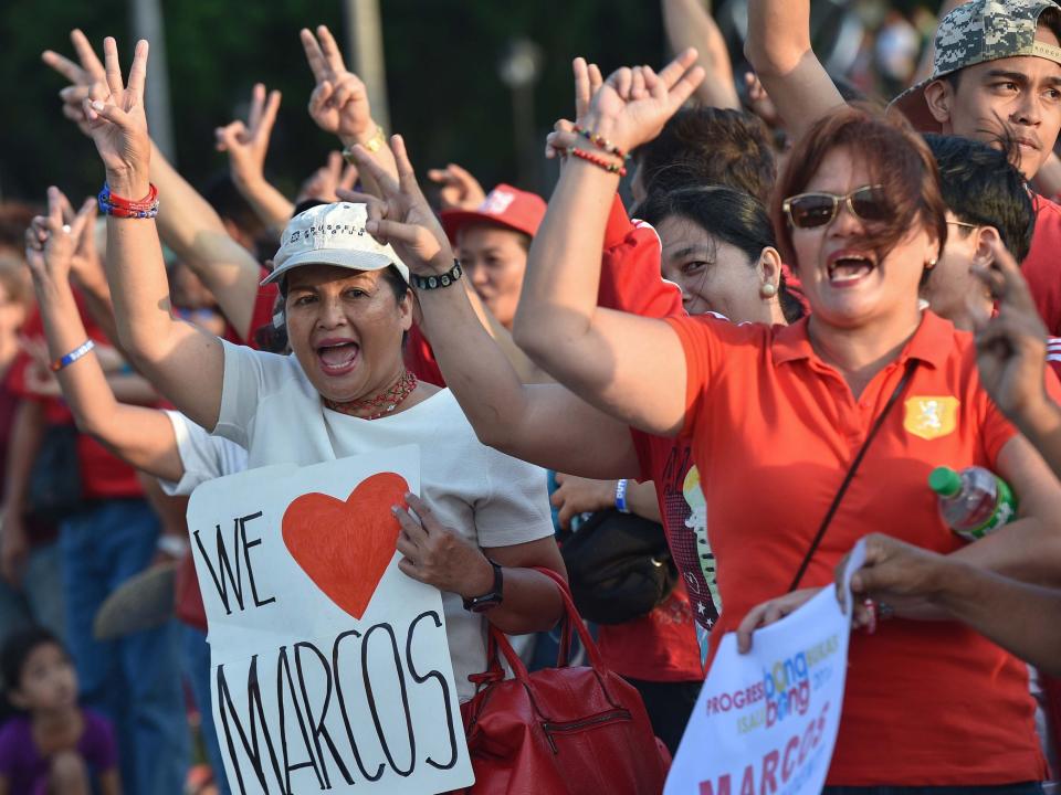 Supporters of Ferdinand Marcos Junior, a vice-presidential candidate and son of the late dictator Ferdinand Marcos, flash the "V" sign as they shout slogans during a protest at a park in Manila on May 11, 2016. -