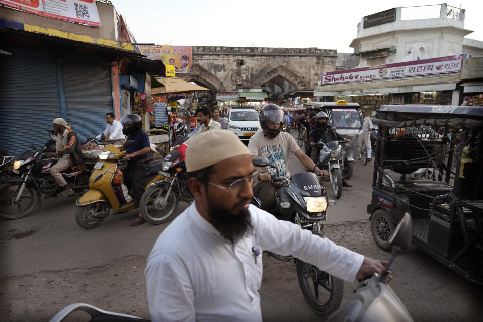 A Muslim man on a motorcycle drives to a Mosque to offer prayers in Ayodhya, India, March 28, 2023. India, a country of more than 1.4 billion people is on the cusp of becoming the world's most populated nation. But most of the Hindus and Muslims embody the opposing sides of a deeply entrenched religious divide that presents India one of its biggest challenges so far: to safeguard freedoms to its Muslim minority at a time when a rising tide of Hindu nationalism is laying waste to the country's secular underpinnings.(AP Photo/Manish Swarup)