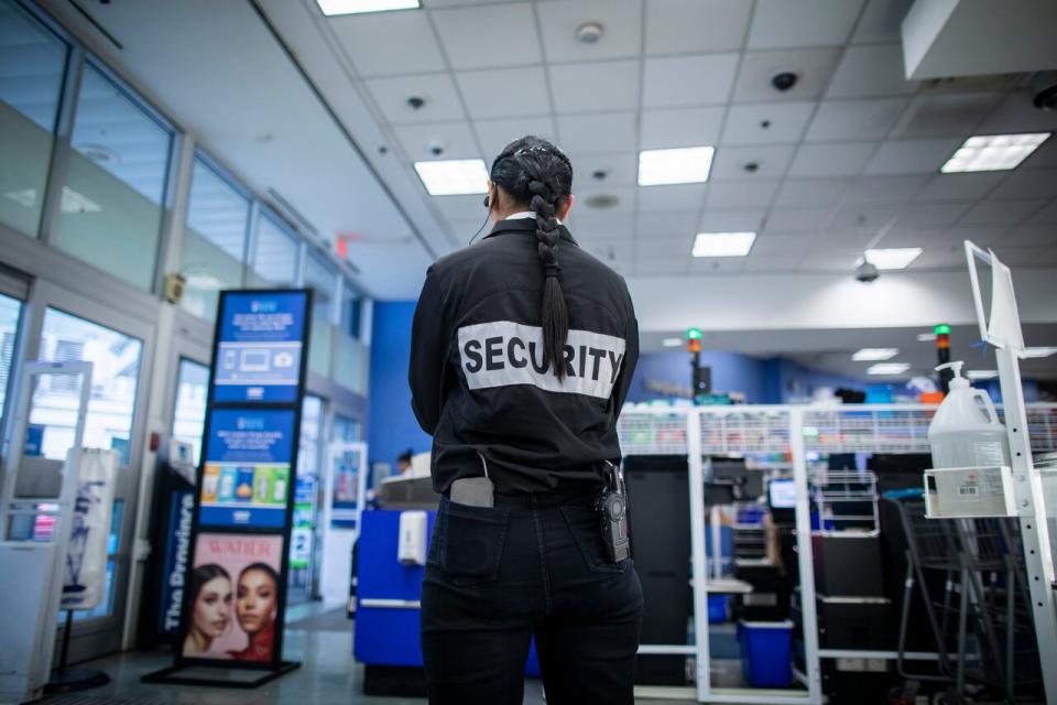 A security guard is pictured monitoring the self checkouts at London Drugs in Vancouver, British Columbia on Monday, October 17, 2023. 