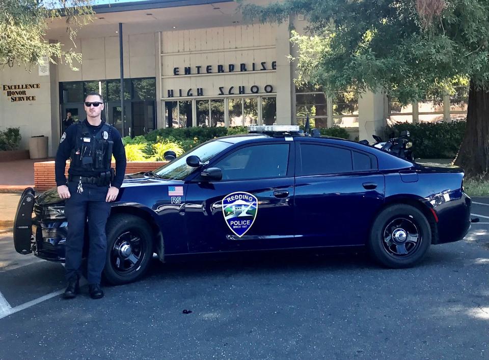 A Redding police officer stands outside Enterprise High School on Wednesday, May 25, 2022. The school went into a lockdown in the morning after reports that a person believed to be a student had a handgun on campus.