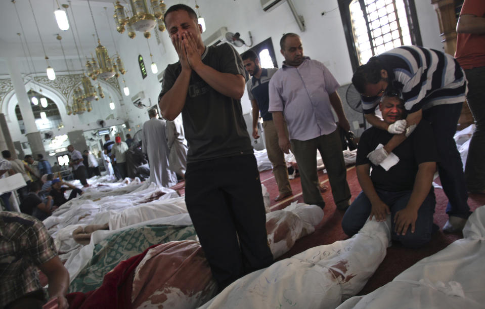 FILE - In this Aug. 15, 2013 file photo, Egyptians mourn over the bodies of their relatives in the El-Iman mosque at Nasr City, Cairo, Egypt. Civil rights and liberties around the world declined for the eighth straight year, dragged down by the Egyptian military's coup, Venezuela clinging to authoritarianism and Russia's crackdown on opposition groups, according to a pro-democracy watchdog group. (AP Photo/Khalil Hamra)