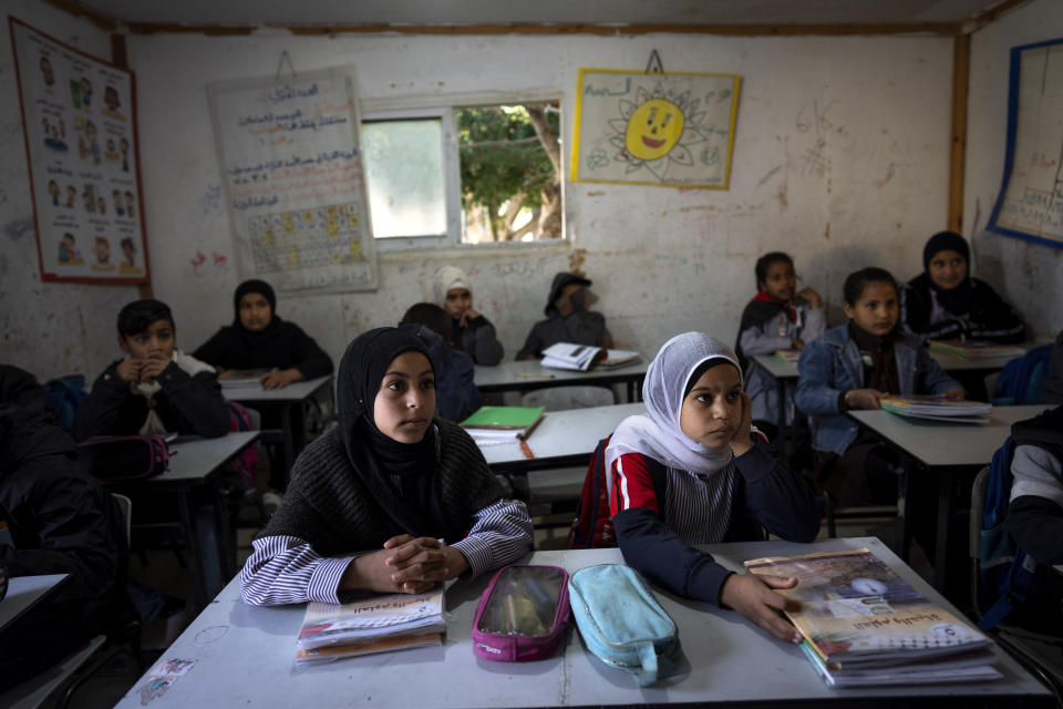 Bedouin students listen to their teacher at a primary school at the West Bank hamlet of Khan al-Ahmar, Tuesday, Jan. 24, 2023. The long-running dispute over the West Bank Bedouin community of Khan al-Ahmar, which lost its last legal protection against demolition four years ago, resurfaced this week as a focus of the frozen Israeli-Palestinian conflict. Israel's new far-right ministers vow to evacuate the village as part of a wider project to expand Israeli presence in the 60% of the West Bank over which the military has full control. Palestinians seek that land for a future state. (AP Photo/Oded Balilty)