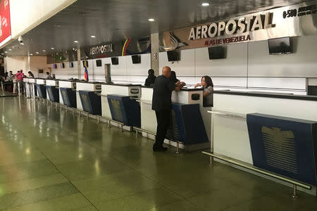 Un hombre conversa con personal de aerolíneas en el mostrador de Aeropostal en el aeropuerto de Simón Bolívar en Caracas, Venezuela. Foto tomada el 2 de julio del 2018. REUTERS/Marco Bello -