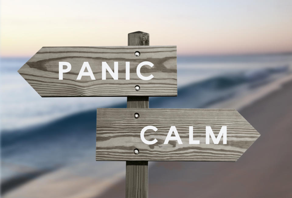 A wooden beach sign pointing in two directions: "Panic" and "Calm."