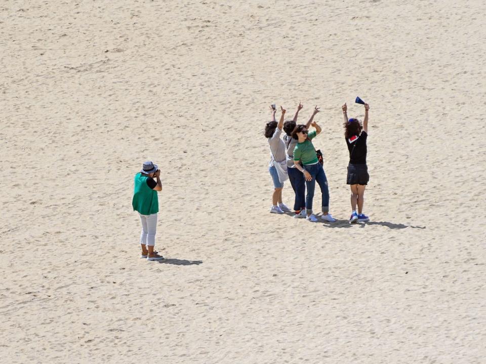 Tourists pose on a beach on Sentosa Island.