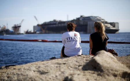 Two women watch the cruise liner Costa Concordia during the refloat operation maneuvers at Giglio Island July 23, 2014. REUTERS/ Max Rossi