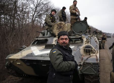 Members of the Ukrainian armed forces and armoured personnel carriers are seen preparing to move as they pull back from Debaltseve region, near Artemivsk February 26, 2015. REUTERS/Gleb Garanich