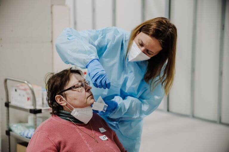 Una agente sanitaria realiza pruebas Covid a personas refugiadas, a su llegada al Hospital Isabel Zendal, a 16 de marzo de 2022, en Madrid.