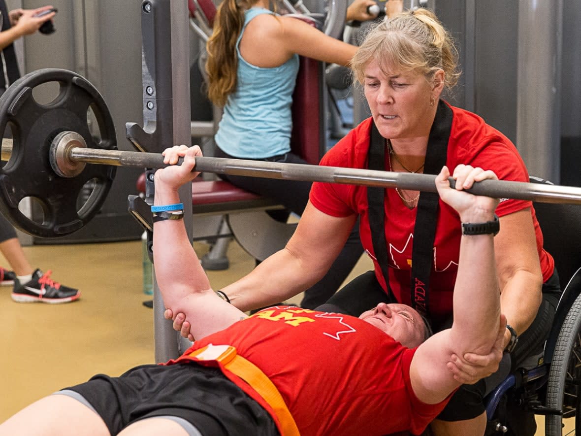 Retired corporal Christine Gauthier spots for retired master corporal Natacha Dupuis on the bench press in training for the Invictus Games. Gauthier told a Commons committee a Veterans Affairs employee offered her assisted death. (David Donnelly/CBC - image credit)