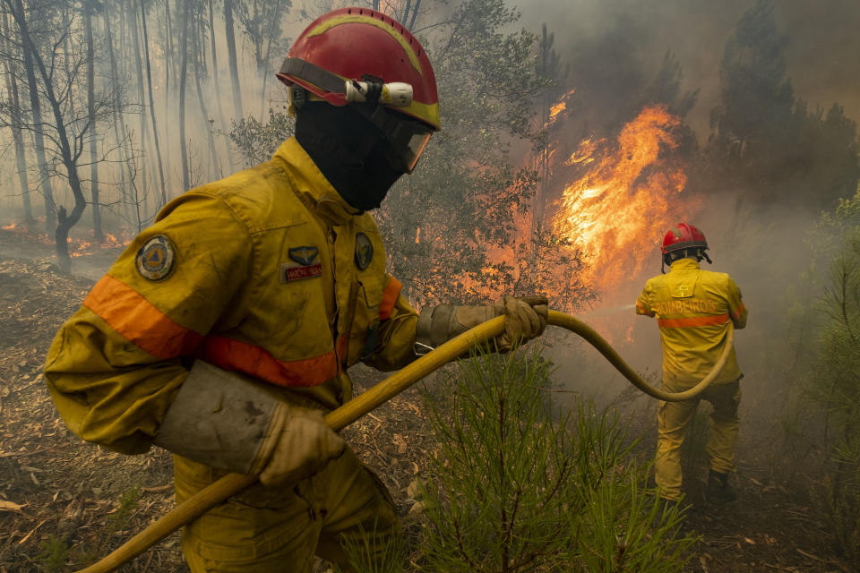 Firefighters try to extinguish a wildfire at the village of Chaveira, near Macao, in central Portugal on Monday, July 22, 2019. More than 1,000 firefighters are battling a major wildfire amid scorching temperatures in Portugal, where forest blazes wreak destruction every summer. About 90% of the fire area in the Castelo Branco district, 200 kilometers (about 125 miles) northeast of the capital Lisbon, has been brought under control during cooler overnight temperatures, according to a local Civil Protection Agency commander. (AP Photo/Sergio Azenha)