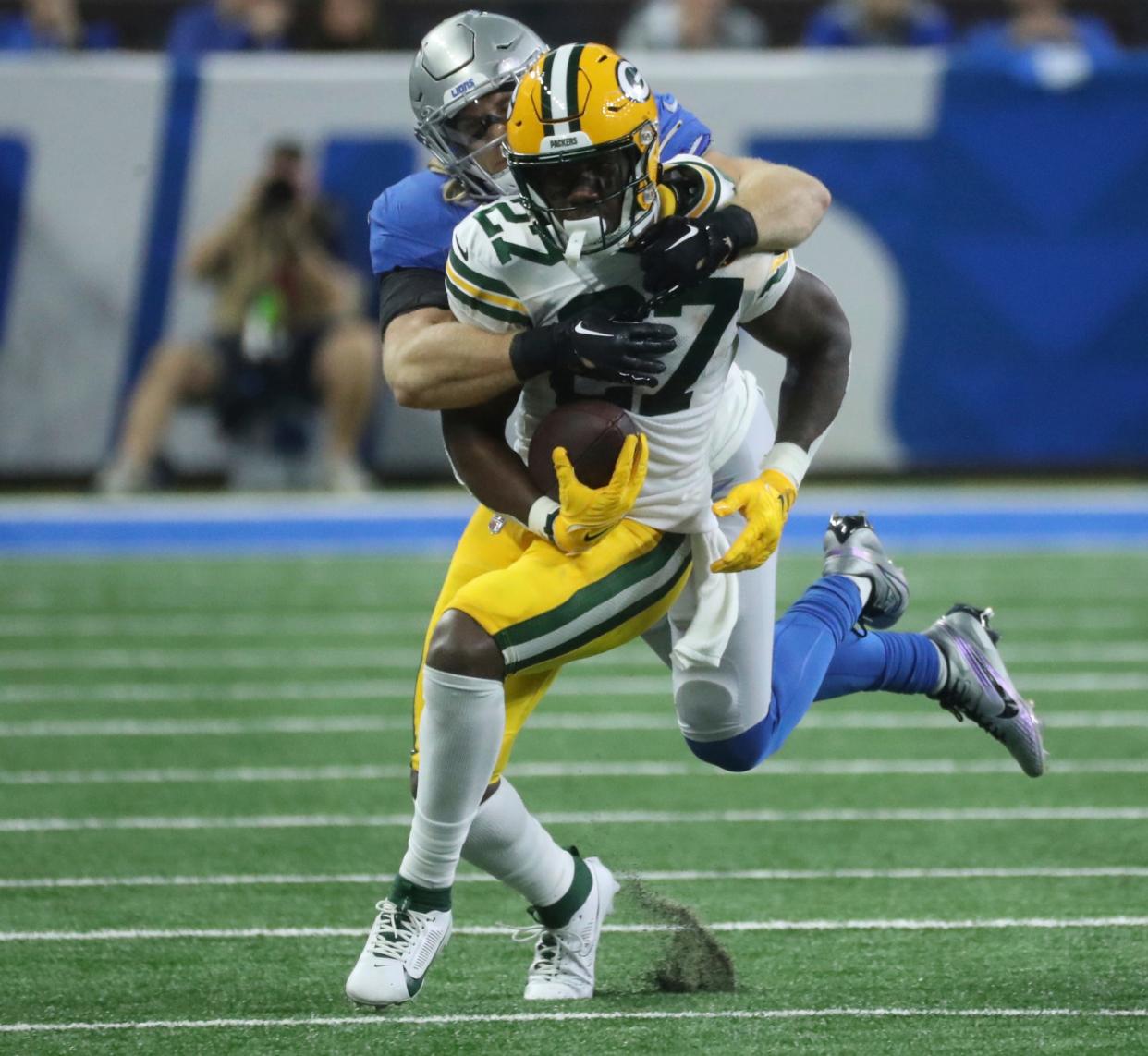 Detroit Lions linebacker Alex Anzalone tackles Green Bay Packers running back Patrick Taylor during the first half at Ford Field, Thursday, Nov. 23, 2023.
