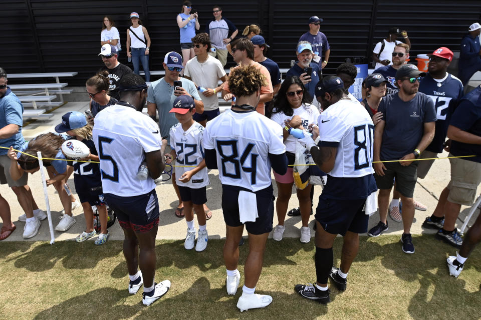 Tennessee Titans Kearis Jackson (5), Gavin Holmes (84) and Reggie Roberson Jr. (80) sign autographs for fans after practice at the NFL football team's training camp, Saturday, July 29, 2023, in Nashville, Tenn. (AP Photo/Mark Zaleski)